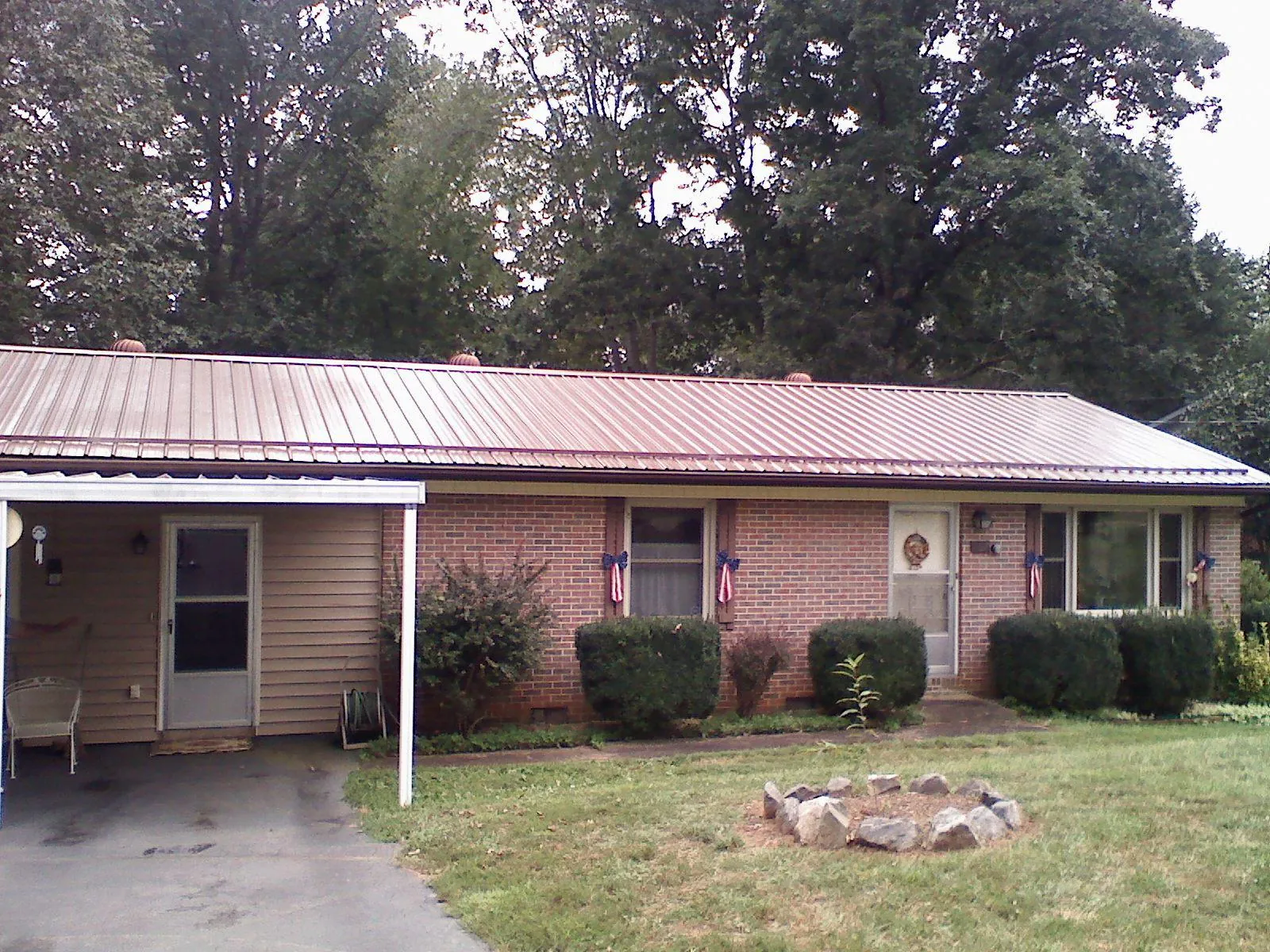 Bronze metal roof and carport on a brick ranch home — Roof Repair work by our crew in Bostic