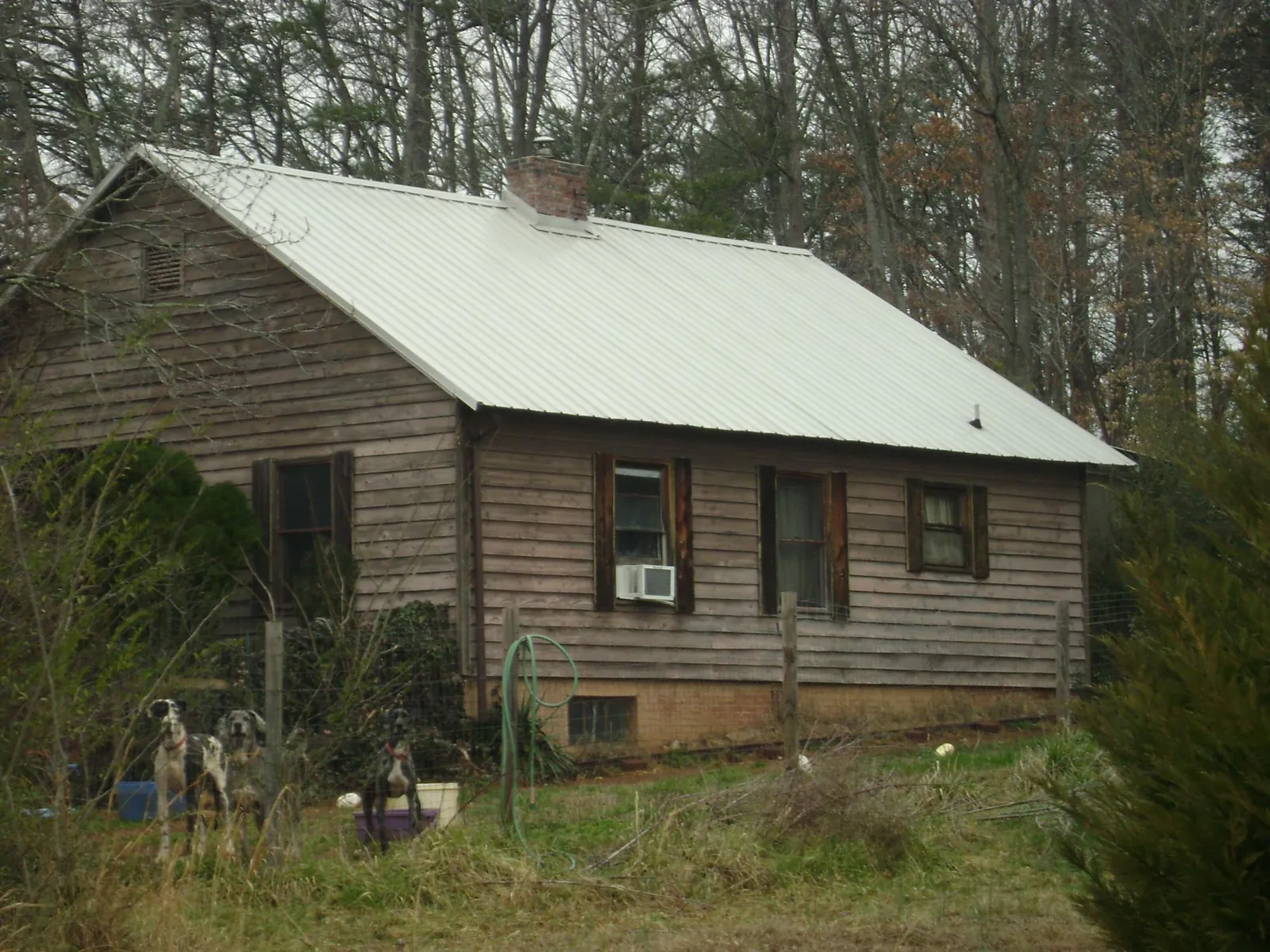 White metal roof on an old wood sided farmhouse, from a Metal Roof Installation job in Bostic